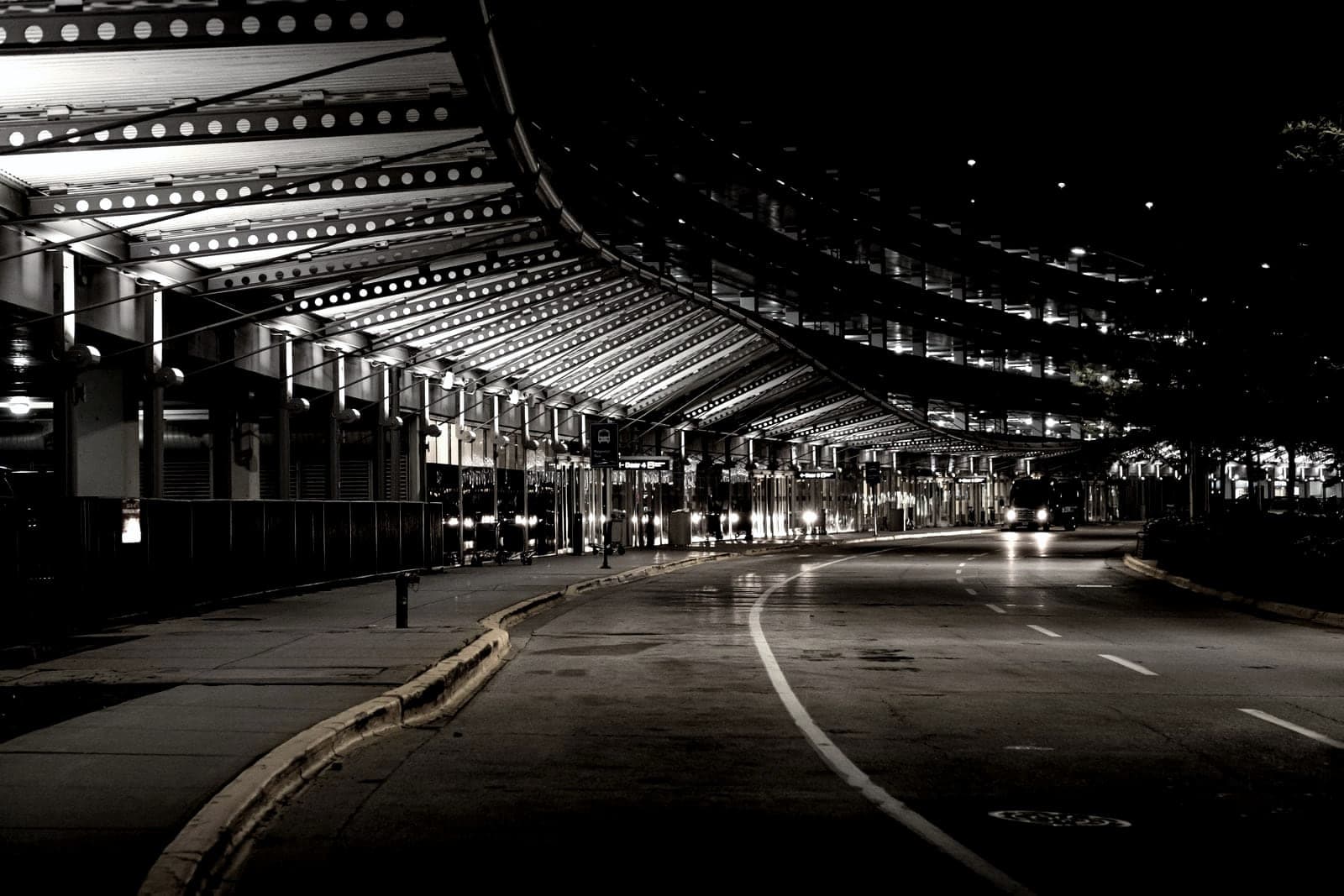 Empty airport terminal curb at night under the canopy lights