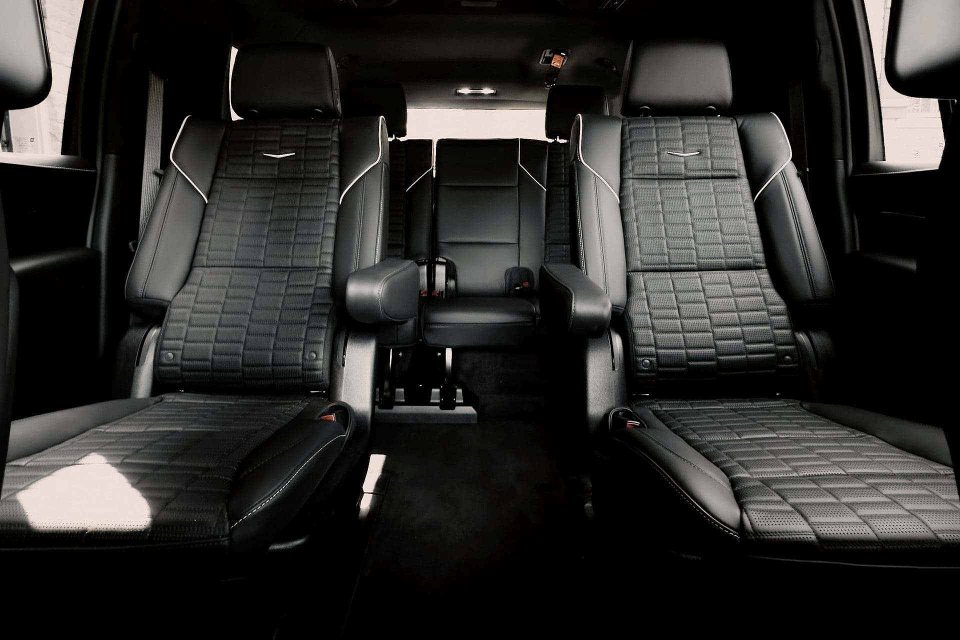 Leather rear cabin of a black SUV lit at night